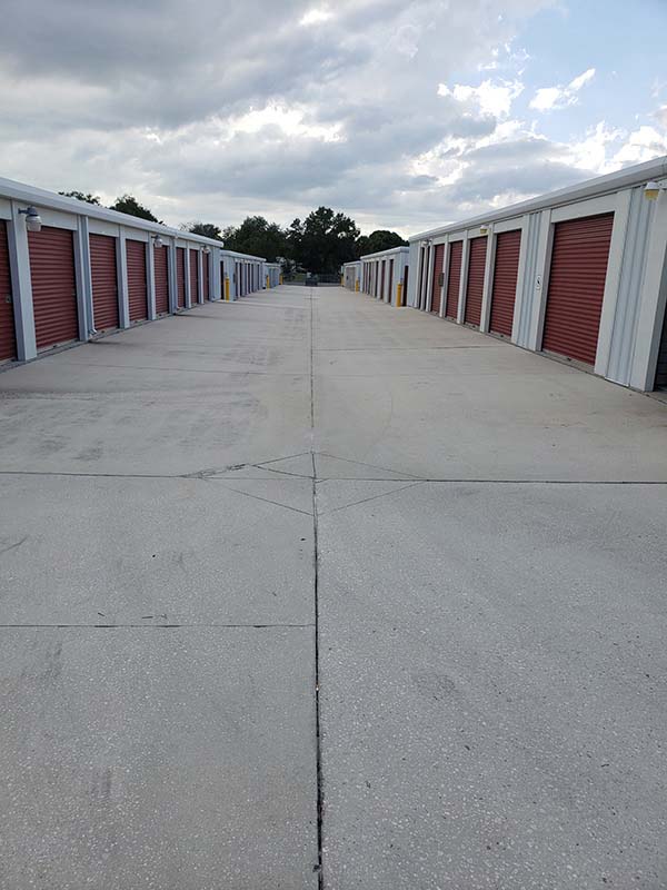 Drive-up storage units with red doors and white trim.