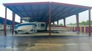 Boats and RV parked in covered storage area.
