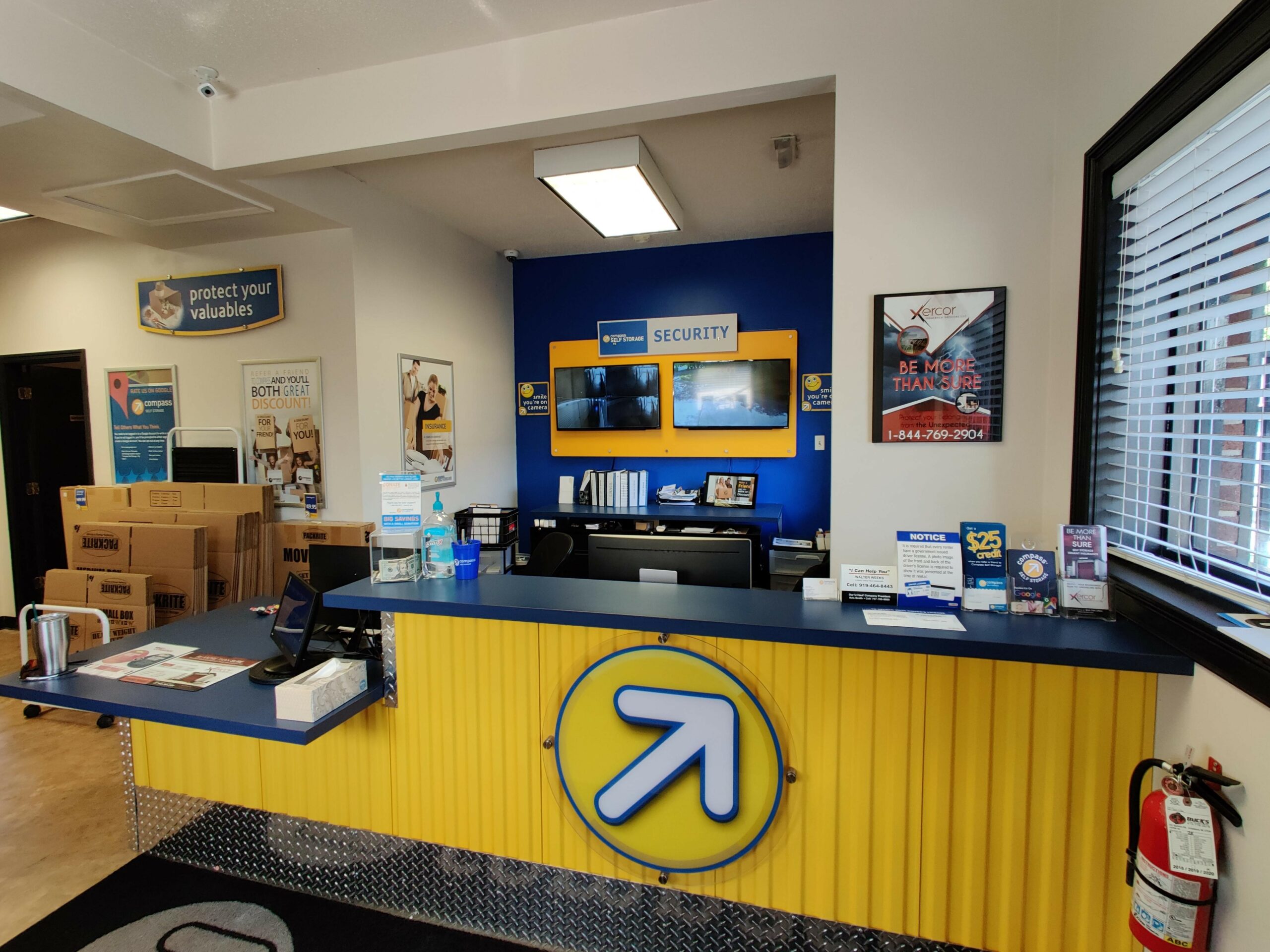 Yellow front desk with Compass Self Storage logo on the front.