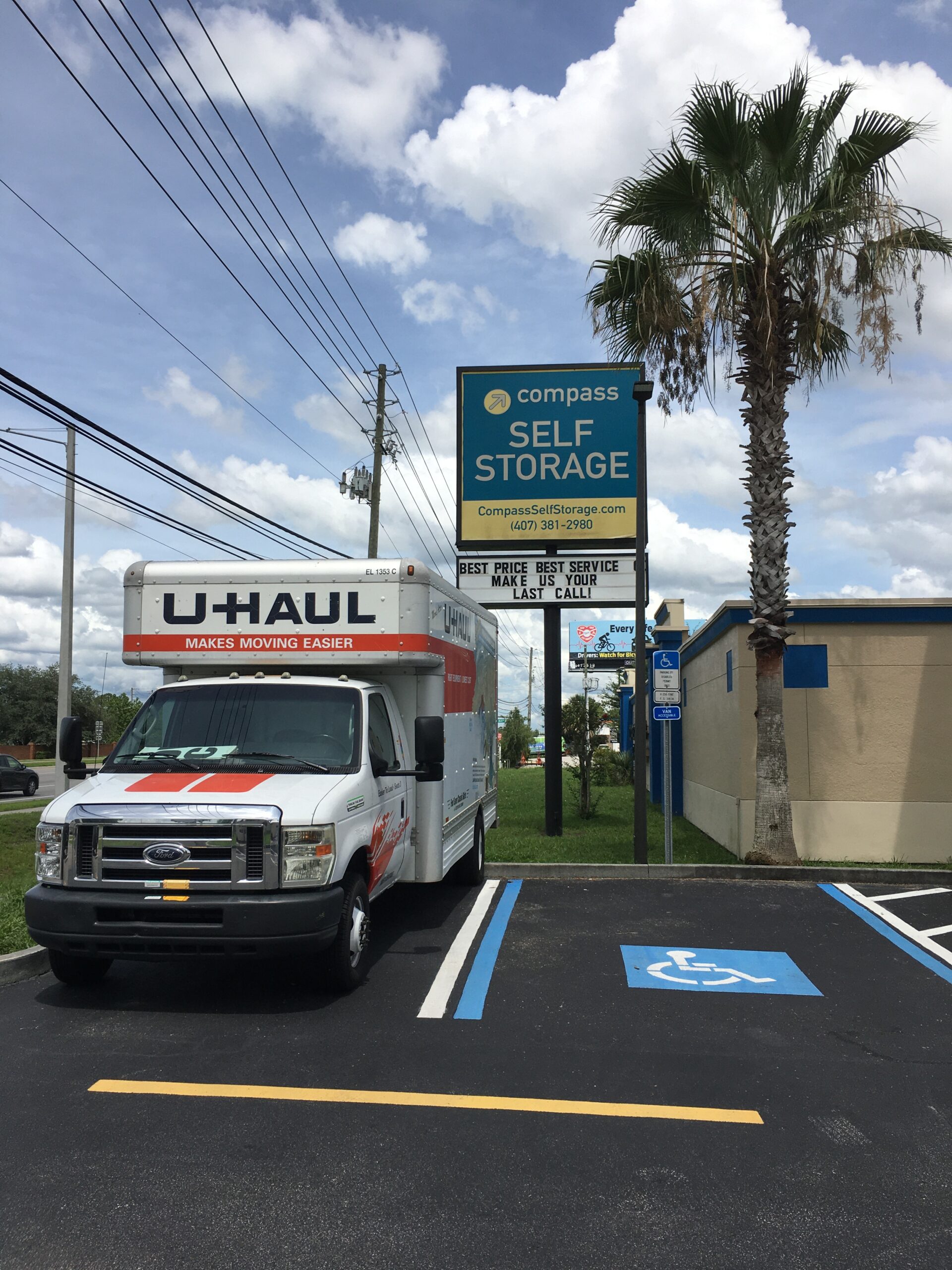 U-Haul truck parked in parking lot of Compass Self Storage facility.