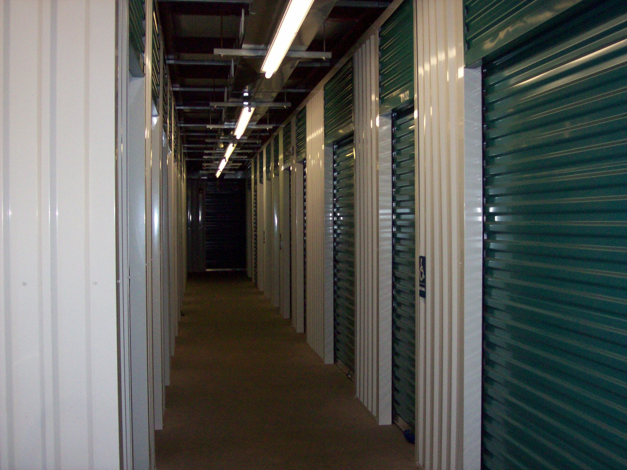 Hallway inside storage facility with indoor storage units at Compass Self Storage.