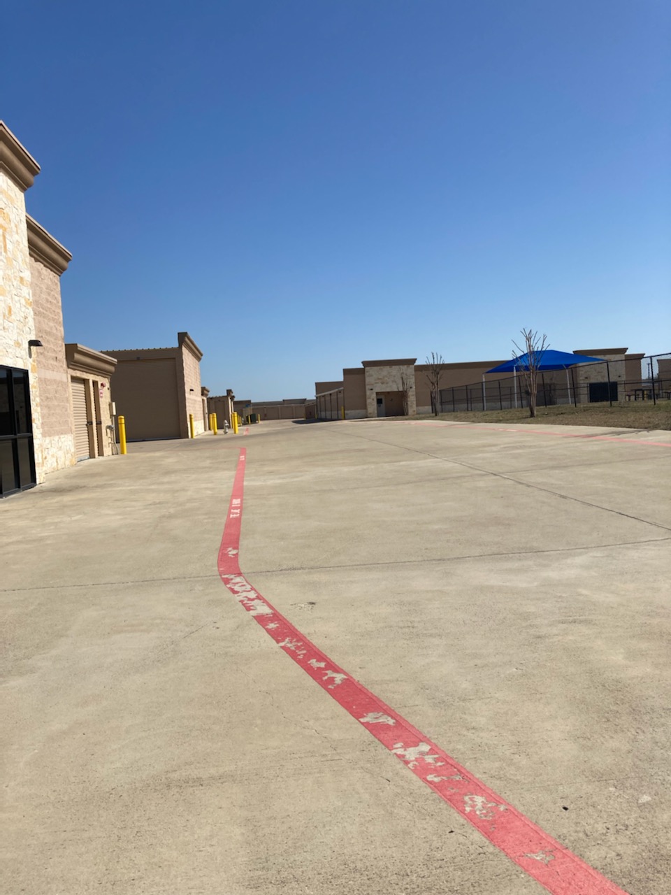 Fenced-in drive-up area in the back of storage facility.
