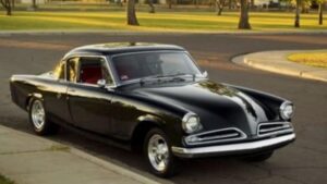 Antique black car parked by a curb.