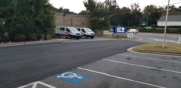 Parking lot at storage facility with U Hauls parked in back.