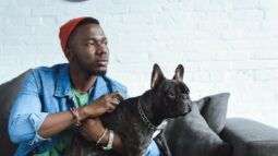 Man holding dog while sitting on a couch.