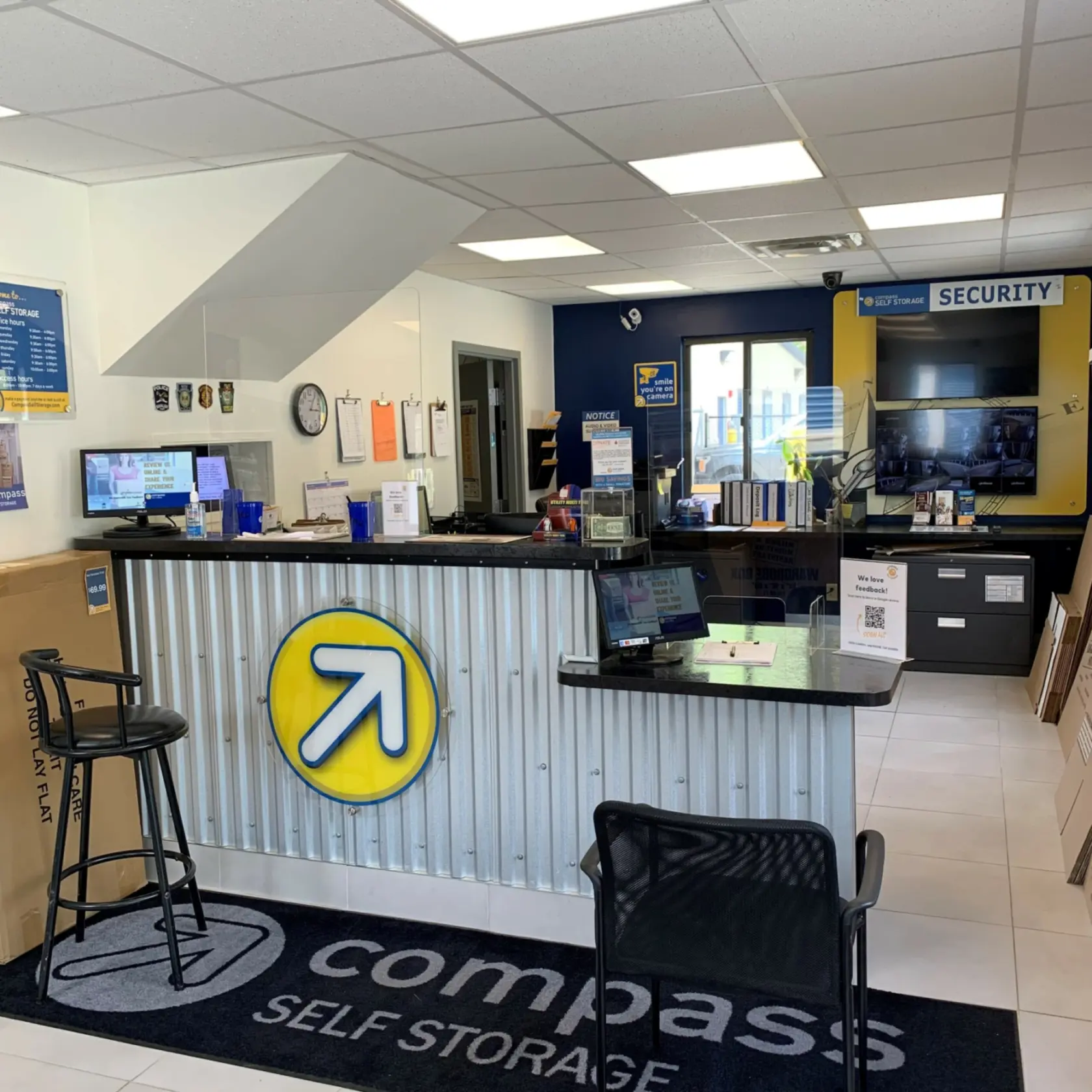 Compass Self Storage front office with security footage on screen.