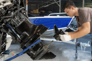a man is performing maintenance on his boat motor and rudder