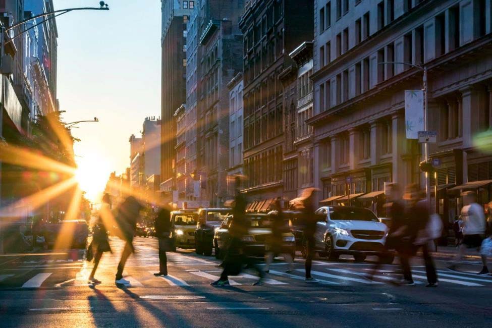 Pedestrians move across the crosswalk in a busy downtown intersection