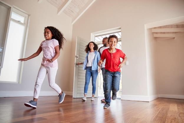 A happy family running into their new home through the front door.