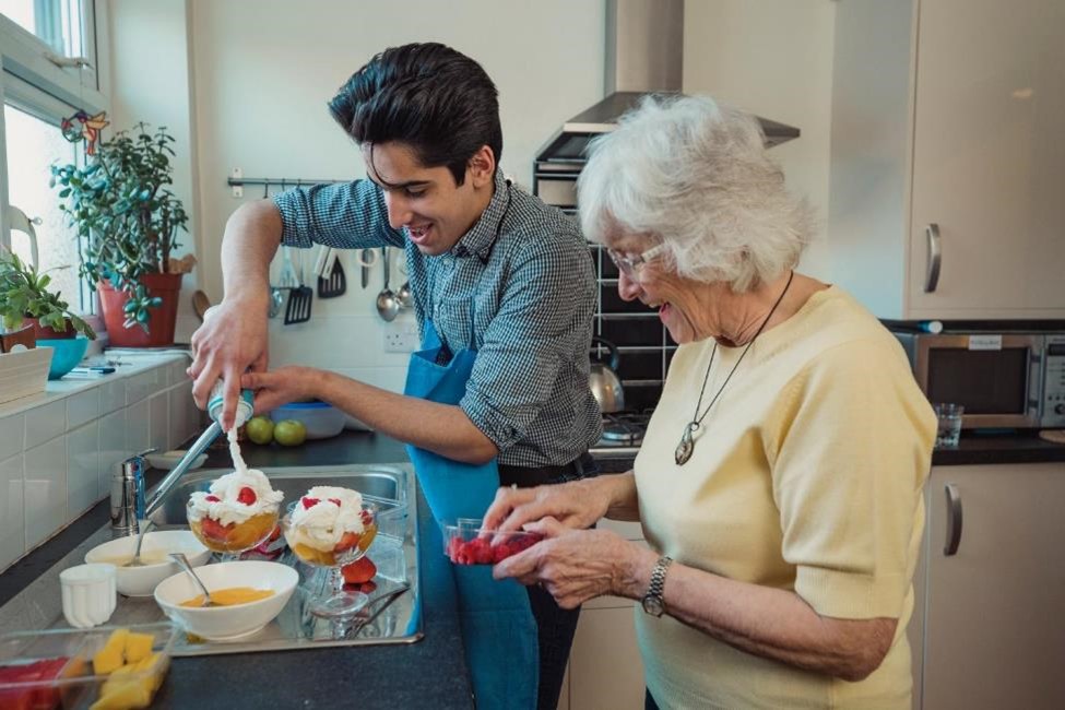 A grandson with his grandma cooking in the kitchen