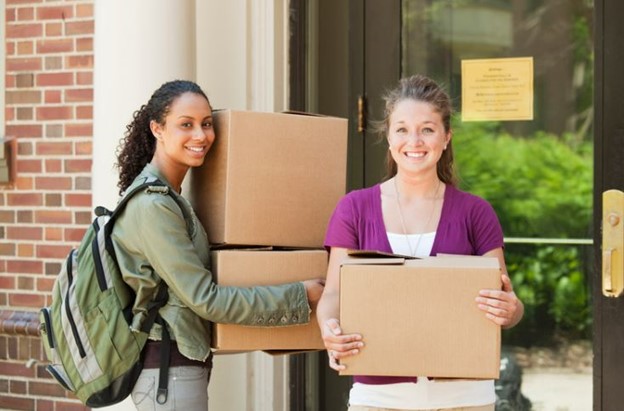Two college students holding boxes
