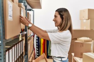 Woman placing a labeled box on shelving unit