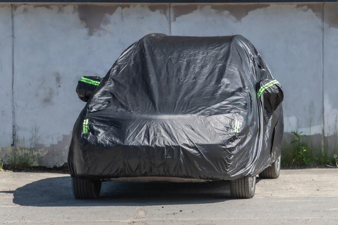 A car covered in black plastic