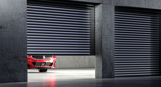 A red car inside a drive-up storage unit. 
