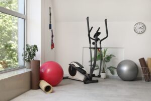Home gym with fit balls, fitness mats, and exercising machine.