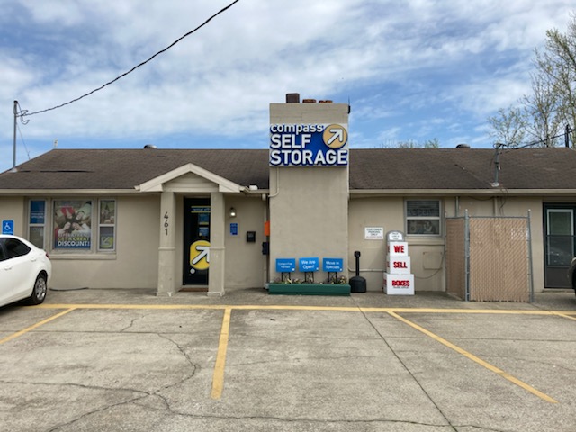 Compass Self Storage facility entrance with a blue sign, 461 address, and available parking spaces.