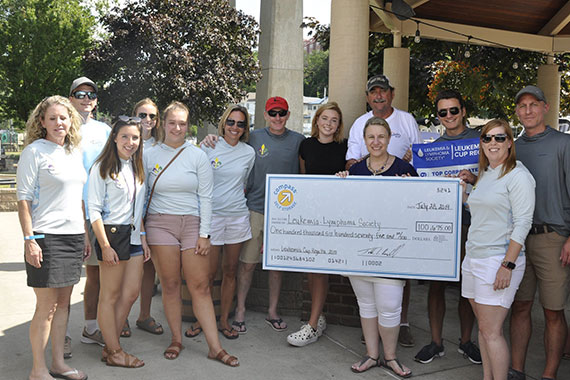 Group of people holding an LLS fundraiser check.