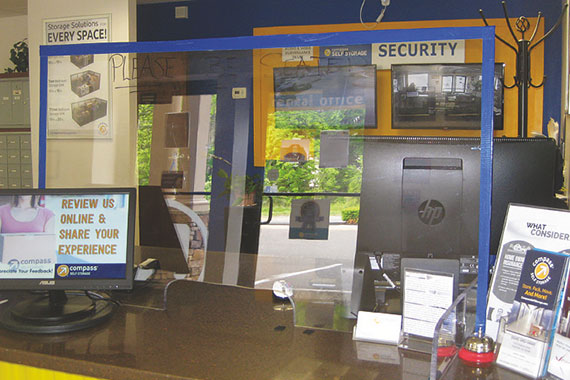 Clear desk shield next to a computer. 